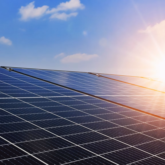 Solarpanels Solarmodule sind vor einem blauen Himmel mit Sonnenschein abgebildet.