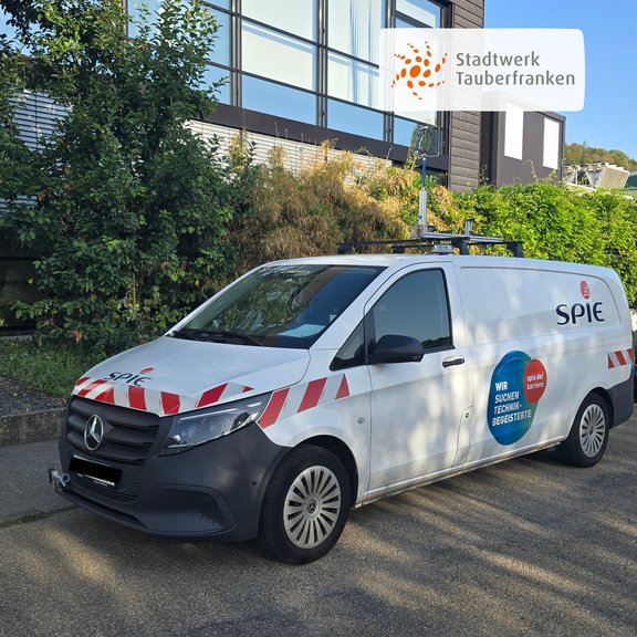 Weißes Messfahrzeug der Firma SPIE mit Sensorik auf dem Fahrzeugdach. Das Fahrzeug wird im Auftrag des Stadtwerks Tauberfranken zur Kontrolle des Gasrohrnetzes und zur Erkennung möglicher Undichtigkeiten eingesetzt.