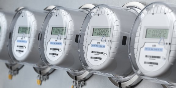 Reihe moderner digitaler Stromzähler mit LCD-Anzeige, installiert an einer Wand – symbolisiert intelligente Energietechnologie und präzise Verbrauchsmessung.