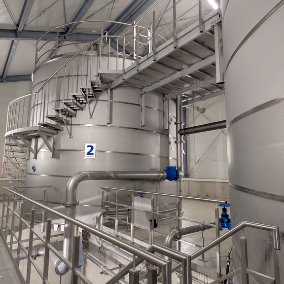 Hochbehälter Stuppach Blick in das Innere des neuen Hochbehälters Stuppach. Zu sehen sind mehrere Edelstahlbehälter, Rohrleitungen, Treppenanlagen und technische Einrichtungen zur Speicherung und Verteilung von Trinkwasser.