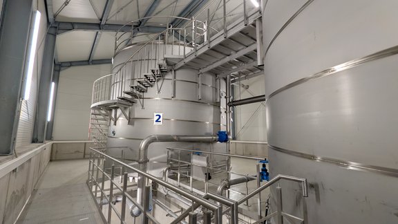Hochbehälter Stuppach Blick in das Innere des neuen Hochbehälters Stuppach. Zu sehen sind mehrere Edelstahlbehälter, Rohrleitungen, Treppenanlagen und technische Einrichtungen zur Speicherung und Verteilung von Trinkwasser.