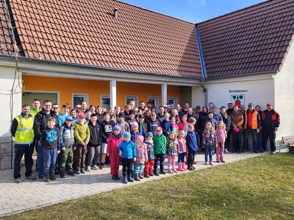 Kehrtwende-Aktion Viele Personen von jung bis alt stehen vor einem Gebäude und lächeln in die Kamera. Die Sonne scheint.