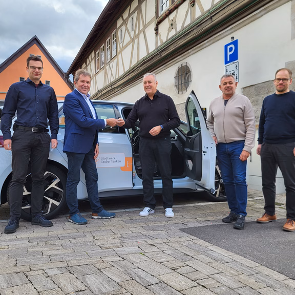 Fünf Personen bei der Fahrzeugübergabe für Carsharing in Grünsfeld mit einem Elektroauto von Stadtwerk Tauberfranken