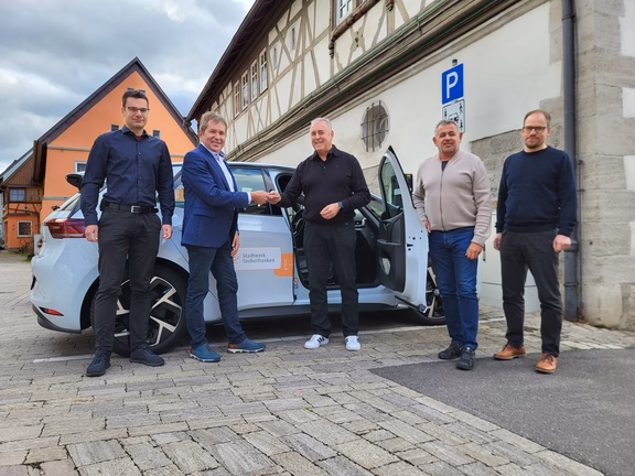 Fünf Personen bei der Fahrzeugübergabe für Carsharing in Grünsfeld mit einem Elektroauto von Stadtwerk Tauberfranken